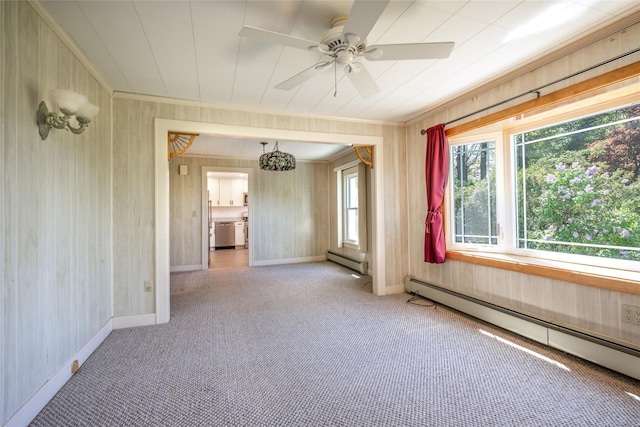 carpeted spare room featuring baseboards, a baseboard heating unit, and ornamental molding