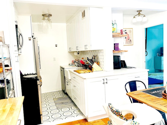 kitchen with white cabinets, appliances with stainless steel finishes, and baseboards