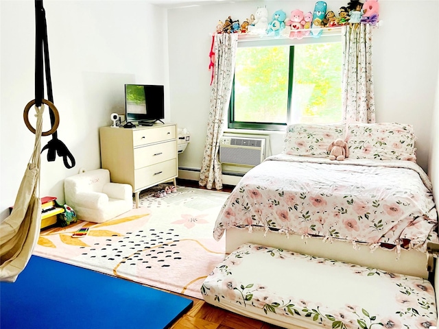 bedroom with a wall unit AC and a baseboard radiator