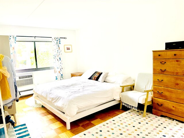 bedroom featuring a baseboard heating unit and wood finished floors