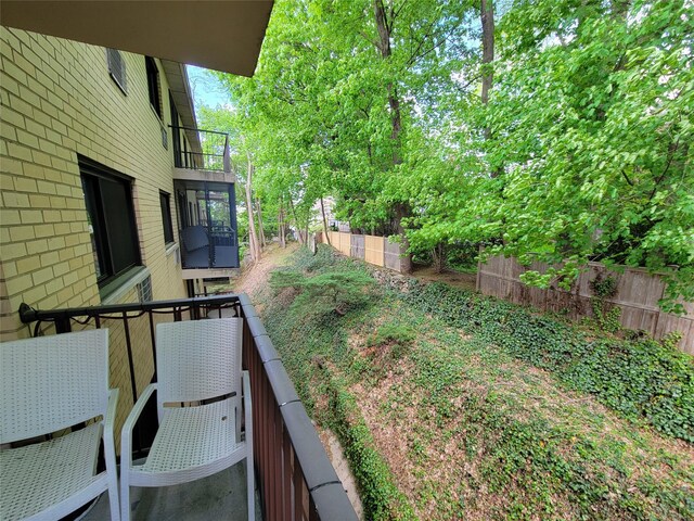 view of yard featuring a balcony and fence