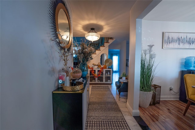 corridor featuring stairway and baseboards