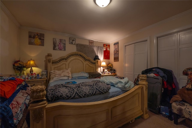 bedroom featuring ornamental molding, carpet, and two closets