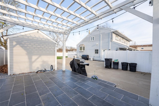 view of patio featuring a pergola, an outbuilding, and a fenced backyard