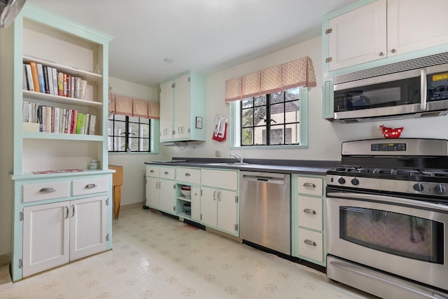 kitchen with a sink, stainless steel appliances, open shelves, and a wealth of natural light