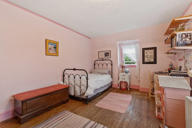 bedroom featuring wood finished floors and baseboards