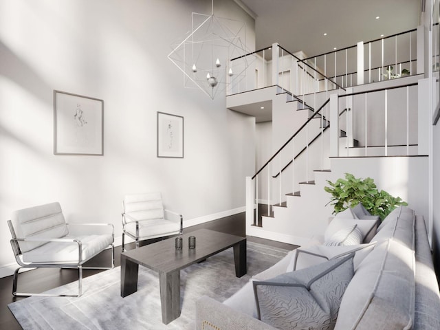 living room featuring baseboards, a notable chandelier, stairway, and a towering ceiling