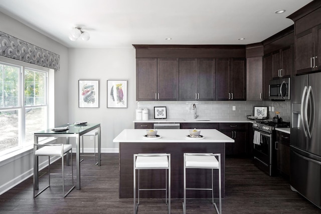kitchen with dark brown cabinets, light countertops, tasteful backsplash, a sink, and stainless steel appliances