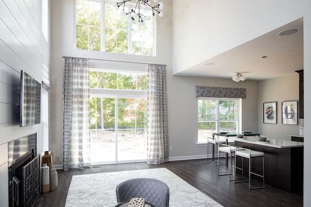 interior space featuring baseboards, dark wood finished floors, a towering ceiling, and a chandelier
