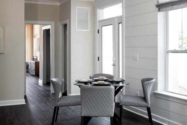 dining area with baseboards, dark wood finished floors, crown molding, and visible vents