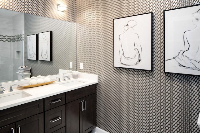 full bathroom with a sink, wallpapered walls, and double vanity