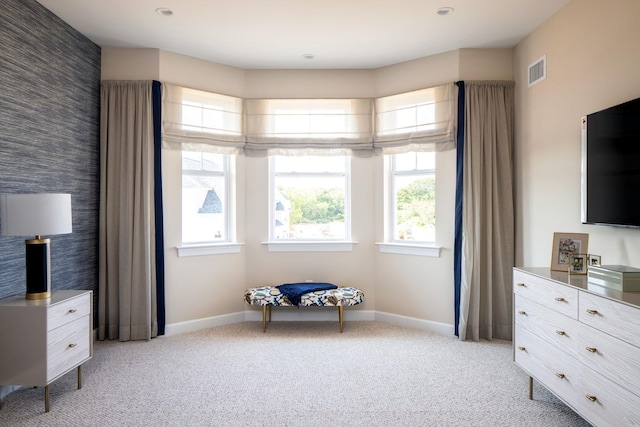 sitting room with baseboards, light carpet, and visible vents