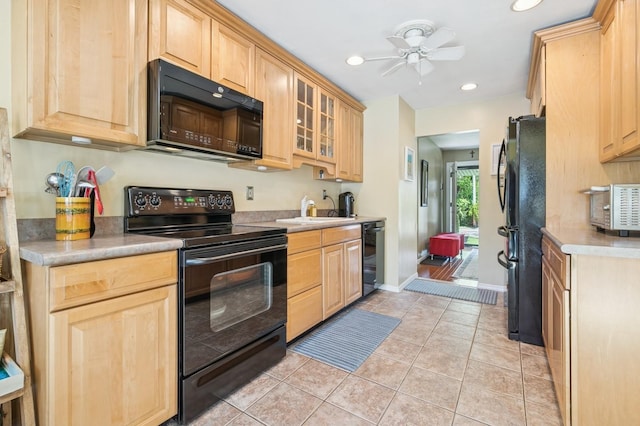 kitchen featuring black appliances, light brown cabinetry, a sink, light tile patterned flooring, and a ceiling fan