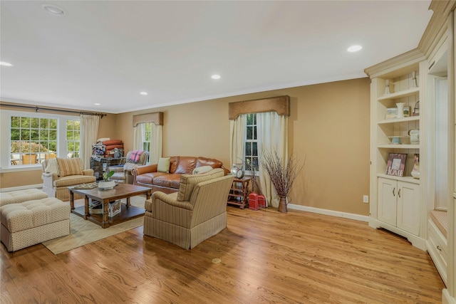 living room featuring recessed lighting, baseboards, ornamental molding, and light wood finished floors