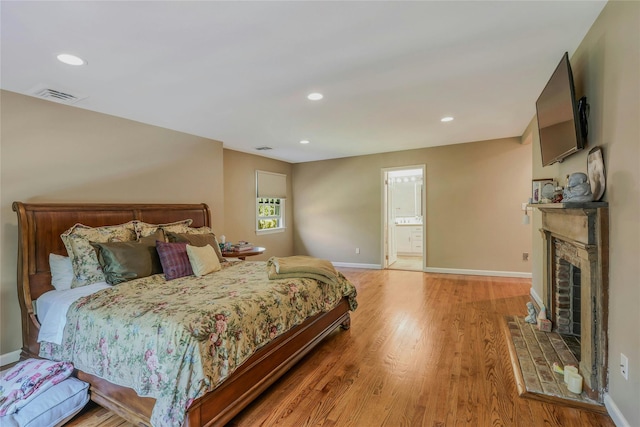 bedroom with visible vents, a fireplace, baseboards, recessed lighting, and light wood finished floors