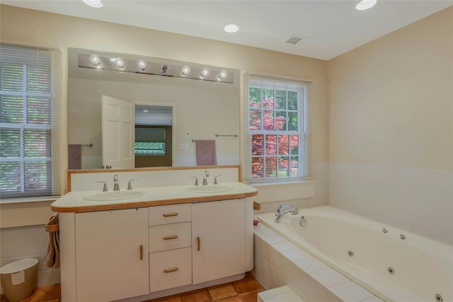 bathroom featuring a sink, a tub with jets, double vanity, and visible vents