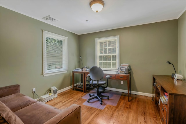 home office with baseboards, wood finished floors, a healthy amount of sunlight, and visible vents