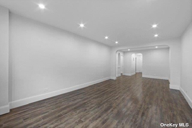 34-24 82nd St Unit 6E, Jackson Heights, NY 11372 - unfurnished living room with arched walkways, recessed lighting, dark wood-type flooring, and baseboards