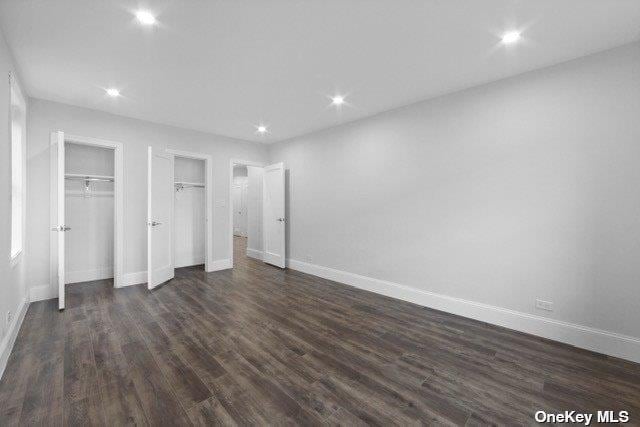 34-24 82nd St Unit 6E, Jackson Heights, NY 11372 - unfurnished bedroom featuring dark wood-type flooring, multiple closets, baseboards, and recessed lighting
