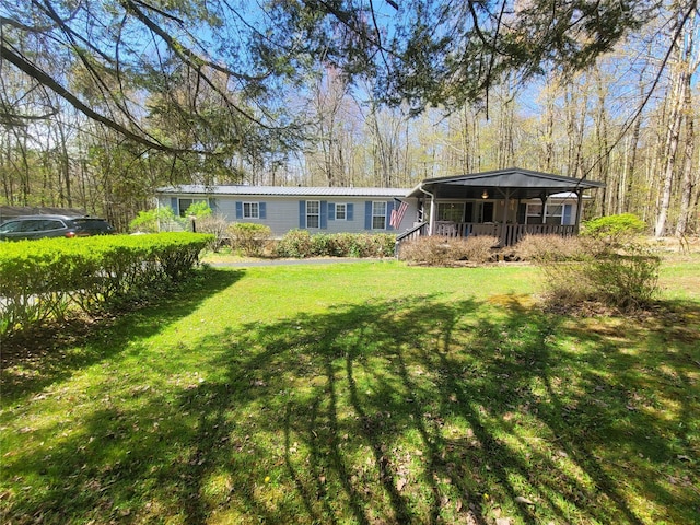 rear view of property with a yard, covered porch, and metal roof