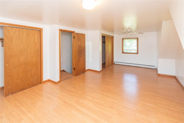 57 E Rock Cut Rd, Walden, NY 12586 - unfurnished bedroom featuring baseboard heating, two closets, light wood finished floors, and baseboards