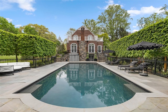 view of swimming pool with a patio area, fence, outdoor lounge area, and french doors