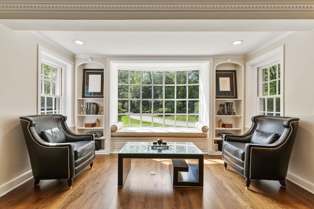 sitting room featuring crown molding, built in features, plenty of natural light, wood finished floors, and recessed lighting