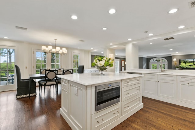 kitchen featuring light countertops, dark wood-style flooring, a sink, white cabinets, and recessed lighting
