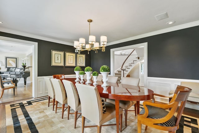 dining space featuring ornamental molding, a chandelier, a wainscoted wall, recessed lighting, and stairs
