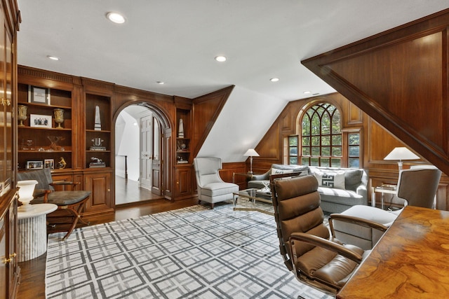 office area featuring vaulted ceiling, arched walkways, wooden walls, wood finished floors, and recessed lighting