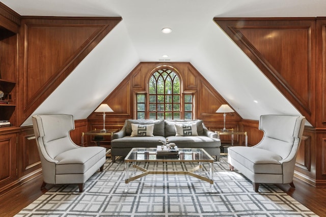 living area with vaulted ceiling, wood finished floors, wooden walls, and recessed lighting