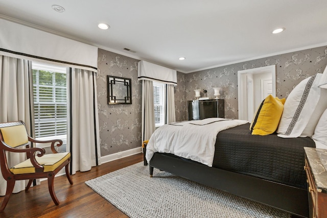 bedroom featuring wallpapered walls, crown molding, wood finished floors, recessed lighting, and baseboards