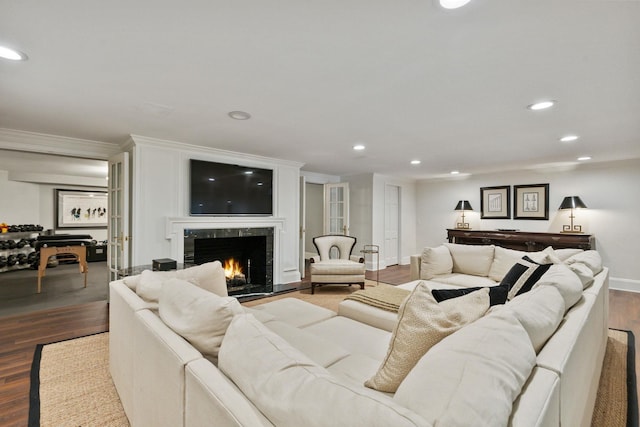 living area featuring crown molding, dark wood finished floors, recessed lighting, a high end fireplace, and baseboards