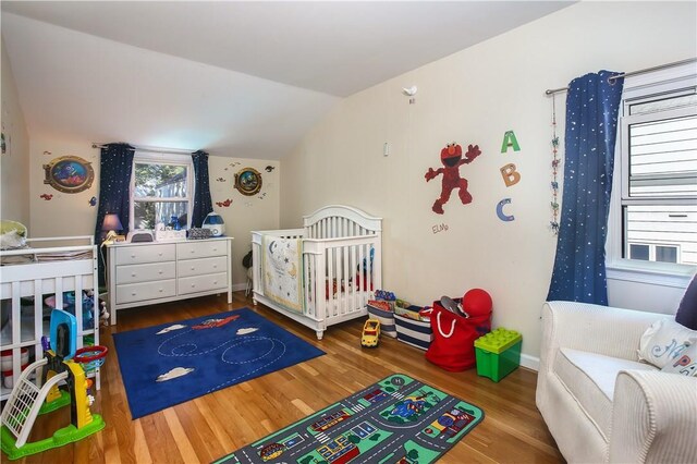 82 Sprague Rd, Scarsdale, NY 10583 - bedroom featuring a nursery area, vaulted ceiling, and wood finished floors