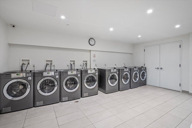 shared laundry area with recessed lighting, independent washer and dryer, and light tile patterned flooring