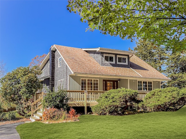 rear view of property with a lawn, a wooden deck, and roof with shingles
