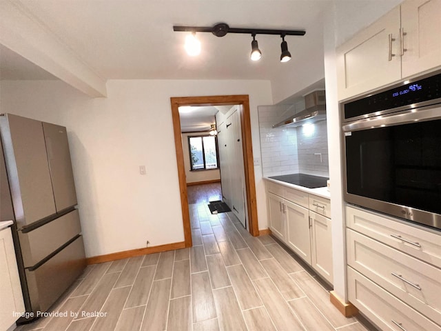 53 Jameson Hill Rd, Clinton Corners, NY 12514 - kitchen featuring stainless steel appliances, wall chimney exhaust hood, tasteful backsplash, baseboards, and light wood-style floors
