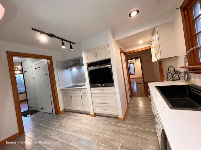 53 Jameson Hill Rd, Clinton Corners, NY 12514 - kitchen featuring oven, a sink, tasteful backsplash, white cabinets, and wall chimney range hood