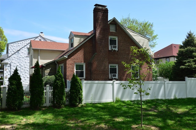 view of side of property featuring fence, a chimney, and a yard