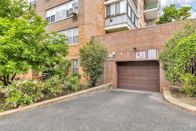 2601 Henry Hudson Pkwy Unit 5E, Bronx, NY 10463 - view of building exterior with asphalt driveway, an attached garage, and cooling unit