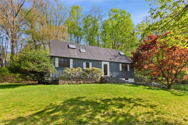 rear view of property with a lawn and central air condition unit