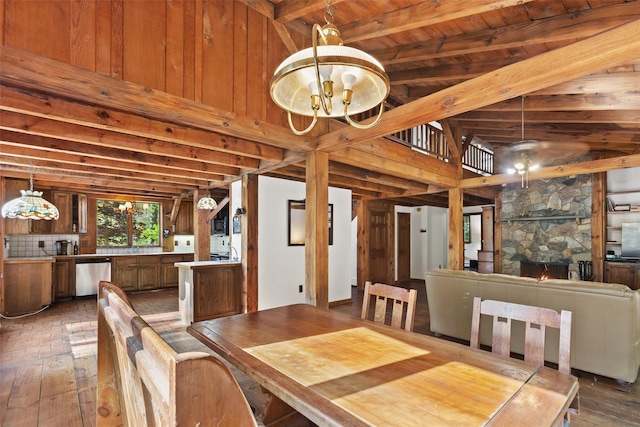 dining space with a chandelier, a fireplace, and wood ceiling