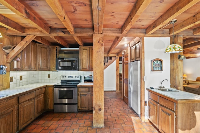 kitchen featuring appliances with stainless steel finishes, tile countertops, a sink, wooden ceiling, and backsplash