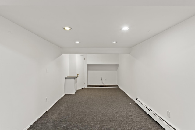 additional living space with a baseboard radiator, recessed lighting, dark colored carpet, and baseboards