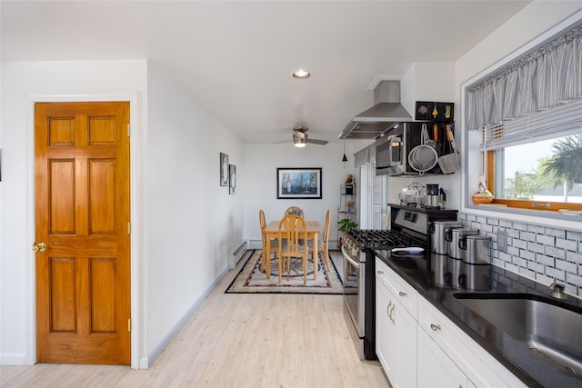 159 Araca Rd, Babylon, NY 11702 - kitchen with stainless steel range with gas stovetop, wall chimney range hood, ceiling fan, light wood-style flooring, and recessed lighting