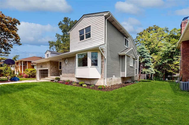 view of front of home with a front yard, a garage, cooling unit, and brick siding