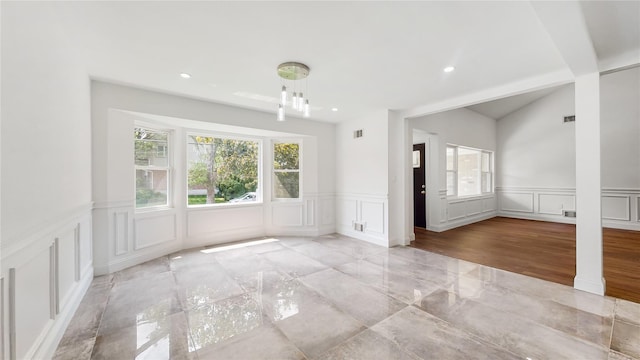 unfurnished dining area featuring a decorative wall, a wainscoted wall, and recessed lighting