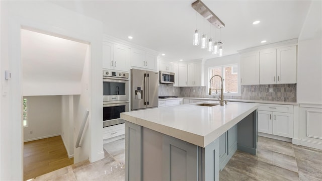 kitchen featuring a sink, stainless steel appliances, tasteful backsplash, light countertops, and recessed lighting