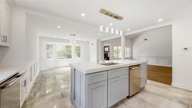 kitchen with a decorative wall, stainless steel dishwasher, a sink, a wainscoted wall, and light countertops