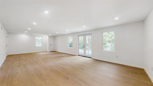 spare room with recessed lighting, light wood finished floors, baseboards, and french doors